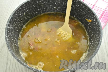 К гречке, копчёным рёбрышкам и овощам вливаем 500 миллилитров воды комнатной температуры, перемешиваем, доводим на достаточно сильном огне до кипения. Воды я добавляю в 2 раза больше, чем гречки, то есть для приготовления 1 стакана гречки мне понадобятся 2 стакана воды. 