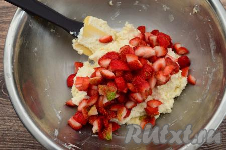 Добавить нарезанную клубнику в миску с творожным тестом. Сок, выделившийся при нарезании ягод, добавлять в тесто не нужно.