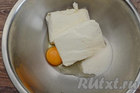 В миску выложить творог, сразу же добавить сахар и сырое яйцо.&nbsp;