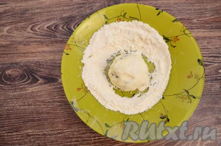 В глубокую тарелку всыпать муку. Зрительно разделить тесто на 7 равных частей (именно столько сырников в результате у нас и получится). Руками, слегка смоченными водой, вначале из одной части теста сформировать округлый сырник.&nbsp;При формировании сырника старайтесь, чтобы ягоды жимолости оказались внутри теста, а не торчали наружу.&nbsp;Сразу выложить сформированный сырник на тарелку с мукой, обвалять его со всех сторон в муке.