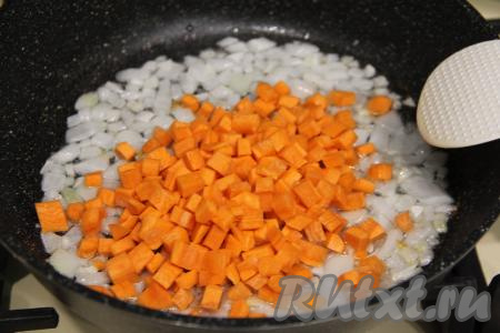 К луку, обжаренному до прозрачности, добавить морковку, нарезанную на мелкие кубики, перемешать, обжаривать минут 7, периодически перемешивая.