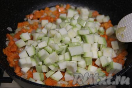 200 грамм подготовленного кабачка нарезать на кубики со стороной 1 сантиметр, выложить к обжаренным морковке и луку, перемешать.