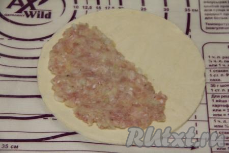 Начинку зрительно разделить на 7 равных частей (по количеству вырезанных кругов). На половину вырезанного круга нанести тонким слоем часть начинки, отступив примерно 1,5 сантиметра от края теста.