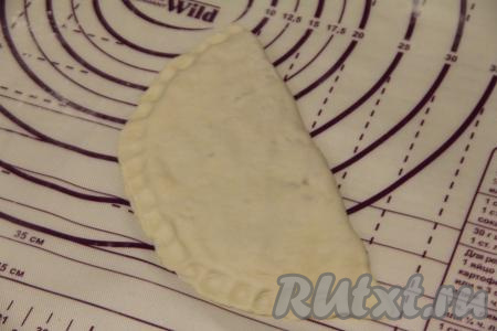 Чистой стороной круга накрыть сторону с начинкой, хорошо скрепить края теста. Я скрепила тесто пальцами, ещё можно скрепить тесто вилкой, периодически окуная зубцы вилки в муку.