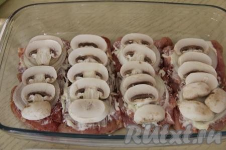 Поверх лука на каждое филе выложить шампиньоны, нарезанные на тонкие пластины.&nbsp;