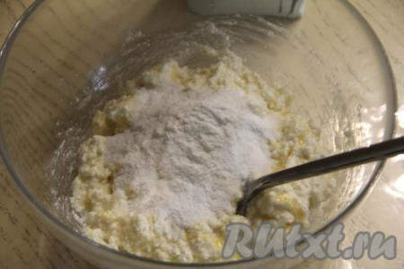 Затем начать по 1 столовой ложке всыпать в миску рисовую муку, каждый раз хорошо вмешивая её в творожное тесто.