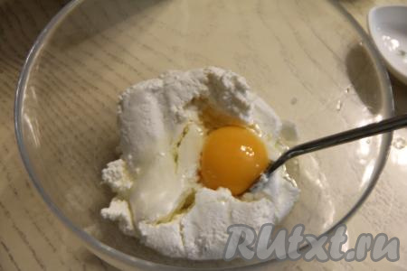 В миску выложить творог и сырое яйцо.