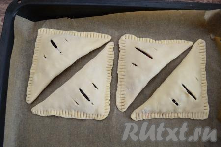 Сформированную слойку с жимолостью выложить на противень, застеленный пергаментом. Постепенно сформировать ещё 3 слойки и тоже выложить на противень, стараясь располагать их на небольшом расстоянии друг от друга.