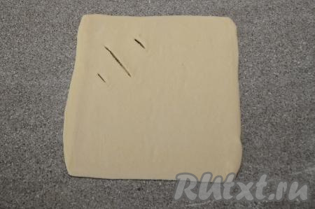 Ближе к одному из углов раскатанного квадрата из теста сделать ножом три разреза.