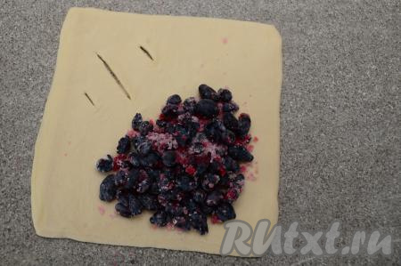 Начинку зрительно разделить на 4 равных части. На каждую заготовку из теста выложить одну часть начинки, располагая её ближе к противоположному углу от угла с разрезами, не забывая отступать от краёв теста по 1-1,5 сантиметра.