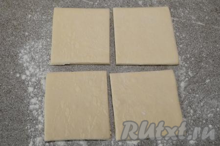 Рабочую поверхность слегка присыпать мукой, выложить пласт разморозившегося теста. Разрезать пласт теста на 4 равных части.