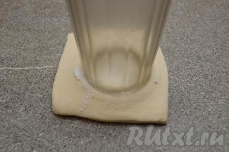 При помощи дна обычного гранёного стакана сделать углубление в центре квадрата. Крахмал здесь выполняет сразу две роли: он не даёт прилипнуть дну стакана к тесту, а в процессе выпечки крахмал желирует соки, выделяющиеся из ягод и фруктов, поэтому начинка не растекается.