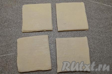 Совсем чуть-чуть припылить стол мукой, выложить разморозившееся тесто. Не раскатывая, разрезать тесто на 4 квадрата.