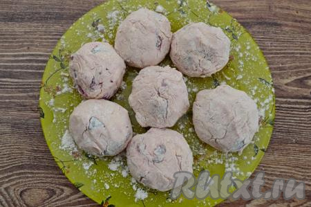 Выложить обваленный в муке сырник на плоскую тарелку, слегка присыпанную мукой. Аналогично сформировать, обвалять в муке и выложить на тарелку ещё 6 сырников с черешней.