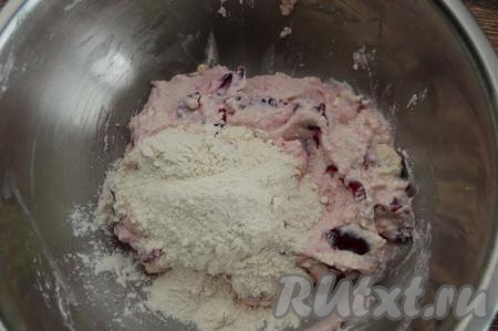 Начать добавлять в творожно-ягодную массу по половине столовой ложки муки, каждый раз хорошо вмешивая муку в тесто.