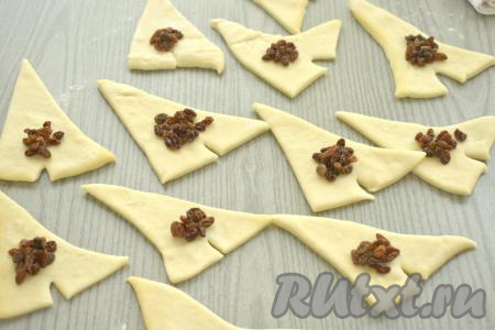 На заготовки из теста возле разреза&nbsp;выкладываем примерно по 0,5 чайной ложки обсушенного изюма.&nbsp;