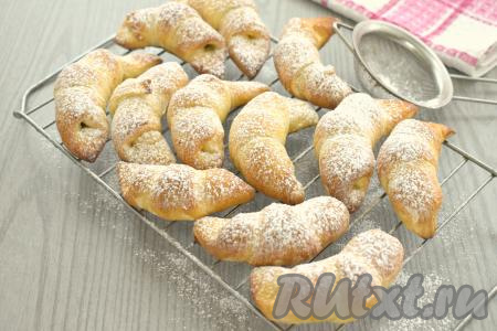 Готовые рогалики достаём из духовки, перекладываем на решётку, оставляем остывать. При желании остывшую выпечку можно посыпать сахарной пудрой.