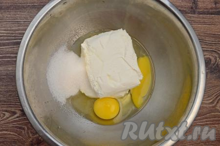 В миску выложить творог, вбить сырые яйца, всыпать сахар.