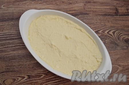 По прошествии 10 минут, когда манка в творожном тесте набухнет, форму для выпечки смазать растительным маслом. Выложить в форму творожное тесто, разровнять. Я использовала для выпечки запеканки овальную форму размером 16 сантиметров на 26 сантиметров.