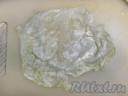 Выложить лист капусты на разделочную доску, слегка отбить кулинарным молоточком утолщённую часть листа.&nbsp;