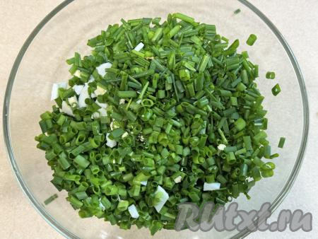 В миску с варёными яйцами добавить мелко нарезанный зелёный лук, перемешать.&nbsp;