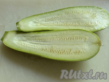 У кабачка отрезать кончики. Разрезать кабачок на две части вдоль.