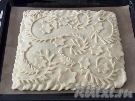 Из оставшейся меньшей части теста сделать узоры, выложить их поверх пирога. Оставить пирог для расстойки на 20 минут.