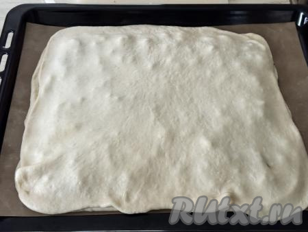 Вторую часть теста тоже раскатать в пласт размером 45 сантиметров на 30 сантиметров,&nbsp;накрыть начинку. Скрепить края теста.&nbsp;