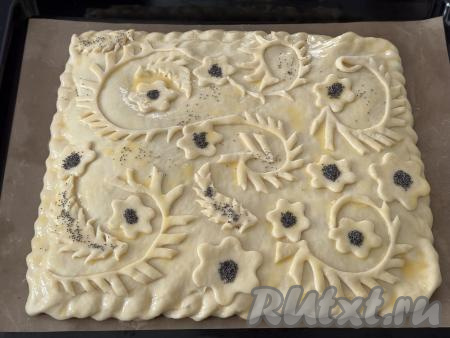 Яичный желток взбить до однородности вилкой в небольшой ёмкости. Смазать поверхность пирога взбитым желтком, по желанию, украсить пирог маком или кунжутом.