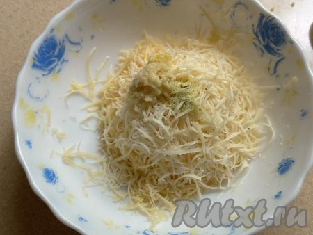 Сыр натереть на мелкой тёрке в глубокую тарелку, добавить очищенный и пропущенный&nbsp;через пресс чеснок, можно приправить немного специями.