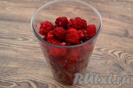 Сложить часть малины в чашку погружного блендера.