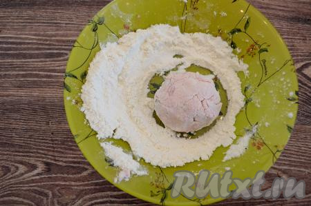 В глубокую тарелку насыпать 2 столовых ложки муки. Творожно-вишнёвое тесто зрительно разделить на 8 равных частей. Для того чтобы тесто меньше липло к ладоням, перед формированием каждого сырника руки нужно смачивать водой. Руками, смоченными водой, вначале из одной части теста сформировать округлый сырник, стараясь, чтобы вишня была внутри сырника, а не на поверхности, затем выложить на тарелку с мукой, обвалять со всех сторон в муке.