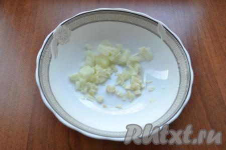 Лук и чеснок очистить. Листья петрушки вымыть и обсушить. Для приготовления заправки для закуски из варёных баклажанов нужно мелко нарезать лук, добавить пропущенный через пресс (или мелко нарезанный) чеснок, выложить в глубокую тарелку.