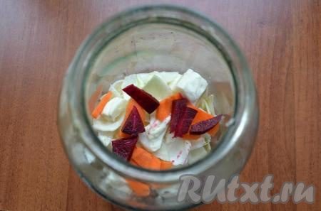 Очищенную свеклу, морковь и чеснок нарезать кусочками. Капусту тоже нарезать кусочками. Часть капусты выложить в чистую 3-х литровую банку, добавить часть свеклы и моркови.