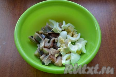 Яйца отварить в течение 10 минут после закипания воды, а затем остудить их и очистить. Масло достать из холодильника нужно заранее, чтобы оно согрелось и стало мягким. Филе сельди осмотреть, удаляя косточки, если они есть. Нарезать селёдку на небольшие кусочки, выложить в глубокую миску (или в другую ёмкость, в которой в дальнейшем будет удобно взбивать погружным блендером), добавить нарезанные варёные яйца (часть желтка я отложила для украшения).