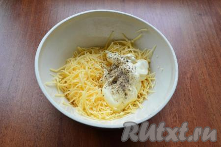 Сыр натереть на мелкой тёрке в глубокую тарелку, добавить майонез и чёрный молотый перец, тщательно перемешать, если нужно, посолить по вкусу.