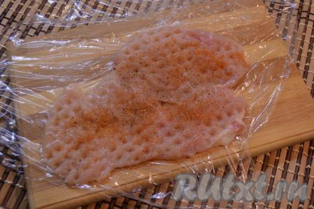 Куриное филе промыть водой, обсушить, затем разрезать вдоль на 2 более тонкие части (в результате у нас получатся 2 отбивные). Накрыть филе пищевой плёнкой и отбить молоточком. Посолить каждую отбивную и посыпать любимыми специями.