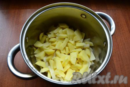 Картошку, лук и морковь очистить. В кастрюлю нарезать небольшими кусочками картофель, затем влить 2 литра воды, поставить на огонь, довести до кипения, снять пену, огонь уменьшить и варить картошку 15 минут.