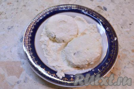 Замешанное тесто разделить зрительно на 6 равных частей. На тарелку всыпать 1,5-2 столовых ложки муки. Руками, смоченными водой, скатать из каждой части теста округлый сырник, обвалять его в муке со всех сторон.