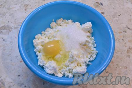 Изюм замочить в кипятке на 10 минут, затем воду слить, а изюм обсушить, разложив на бумажном полотенце. К творогу добавить соль, сырое яйцо, всыпать сахар.