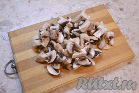 Шампиньоны промыть водой, убирая загрязнения с грибов, затем нарезать на не очень тонкие пластины.