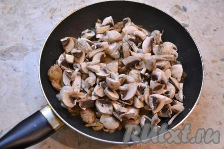 Добавить шампиньоны к свинине и луку, перемешать и обжаривать ещё около 5 минут, время от времени перемешивая.