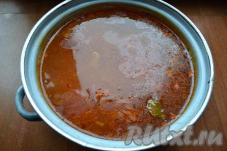 После того как картошка с рисом и свининой с момента закипания проварятся 20-25 минут (и картофель, и рис, должны стать достаточно мягкими), выложить в кастрюлю заправку со сковороды, добавить специи и лавровый лист. Дать рассольнику закипеть, подсолить по вкусу, уменьшить огонь, проварить 5-7 минут.