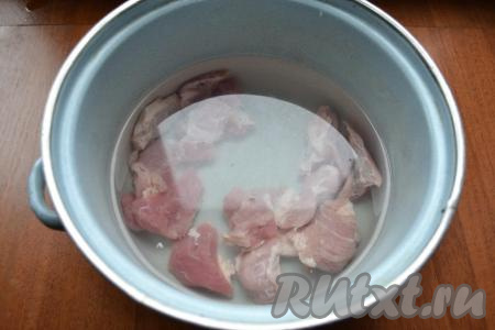 Свинину (можно взять как мякоть, так и, например, рёбрышки на кости) нужно вымыть и, нарезав на порционные кусочки, поместить в кастрюлю, залить 3 литрами воды, поставить на огонь. После закипания воды снять пену, уменьшить огонь, варить мясо 30 минут.