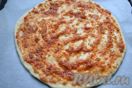 Тесто обмять, на столе, присыпанном мукой, раскатать в пласт толщиной около 1 см. Выложить тесто на противень, застеленный бумагой для выпечки. Смазать тесто томатным соусом.