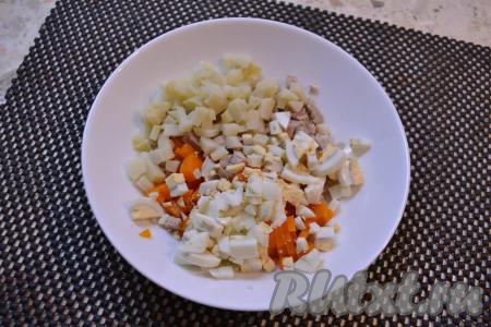 Картошку и яйца очистить, нарезать на кубики примерно такого же размера, как нарезаны морковка и курица. Нарезанные яйца и картофель выложить в миску с куриным мясом и морковью.
