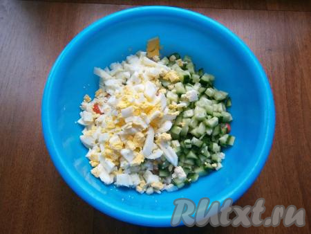 Свежий огурец вымыть, обрезать кончики с двух сторон. Огурец и варёные яйца нарезать на небольшие кубики, добавить в миску с крабовыми палочками.