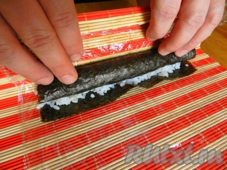 С помощью салфетки свернуть ролл довольно плотно.