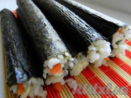 Таким образом поступить со всеми листами нори, или пока не закончится начинка. Острым ножом, смоченным в воде, разрезать роллы на части - сначала пополам, затем каждую часть еще на 3 части. 