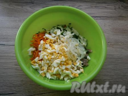 Лук отжать от маринада и добавить в салат вместе с рубленными яйцами.